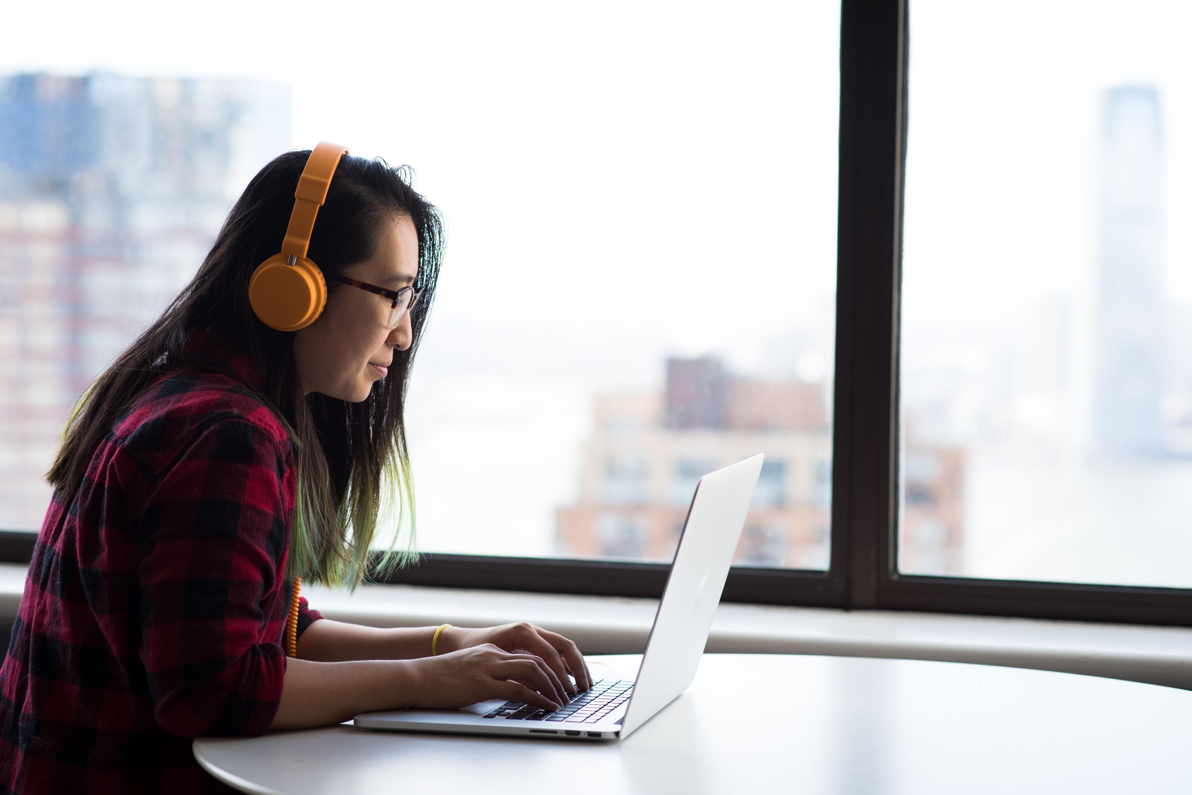 Neue Mitarbeiterin beim digitalen Onboarding mit Laptop und Online-Schulungen im Homeoffice Neue Mitarbeiterin beim digitalen Onboarding mit Laptop und Online-Schulungen im Homeoffice