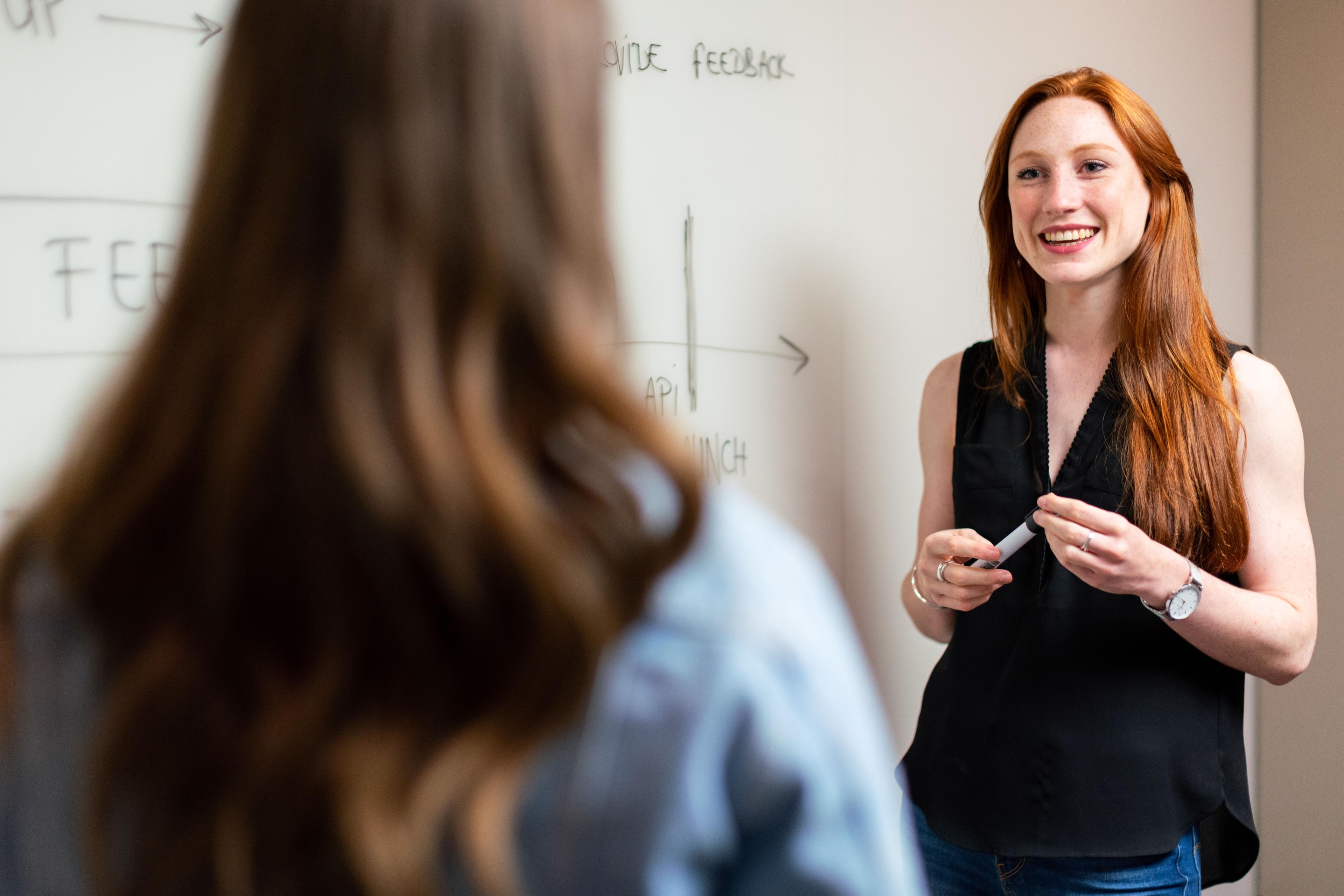 Zwei Personen im Gespräch an einem Tisch im Büro Zwei Personen im Gespräch an einem Tisch im Büro