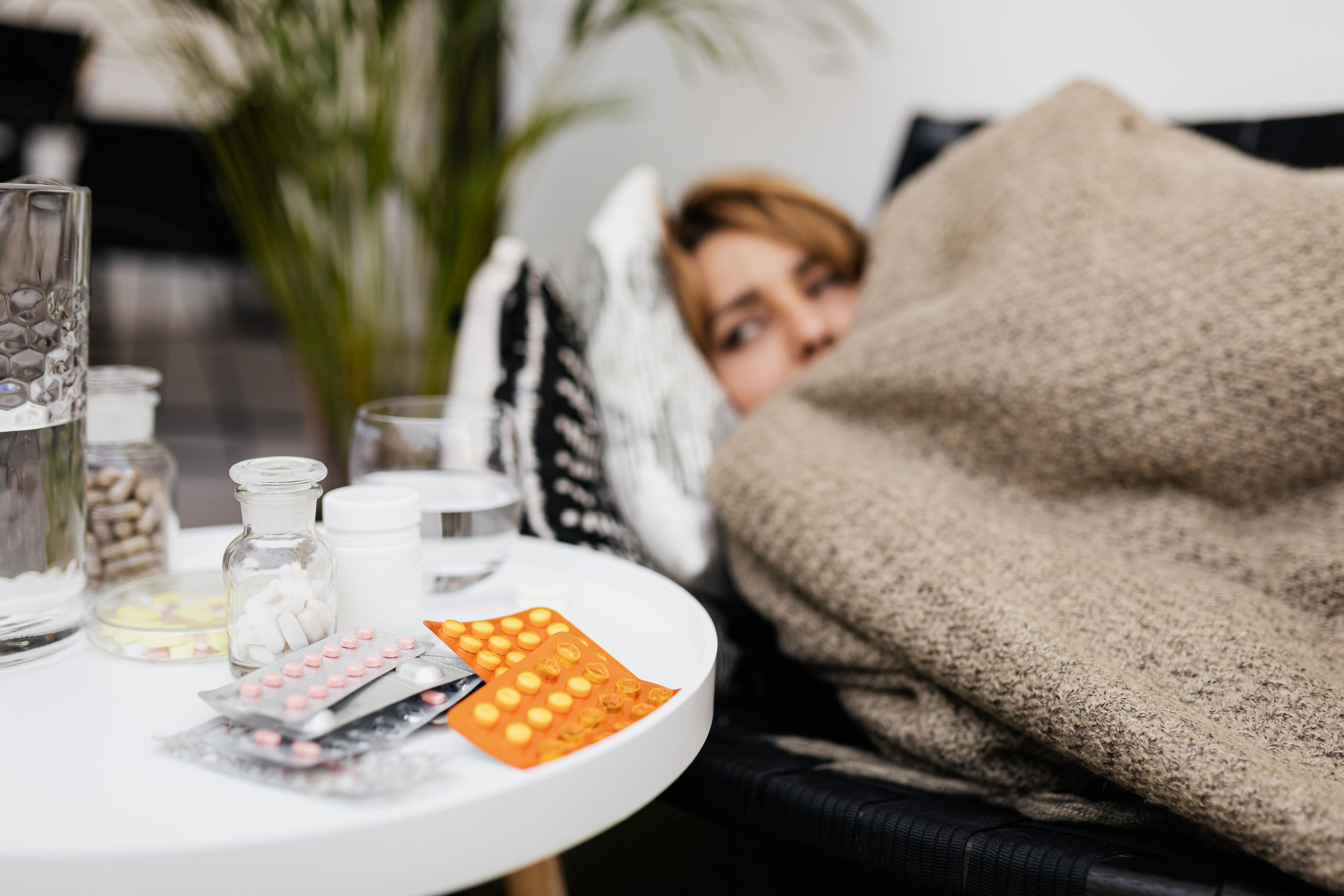 Kranker Arbeitnehmer liegt im Bett und meldet sich krank beim Arbeitgeber Kranker Arbeitnehmer liegt im Bett und meldet sich krank beim Arbeitgeber
