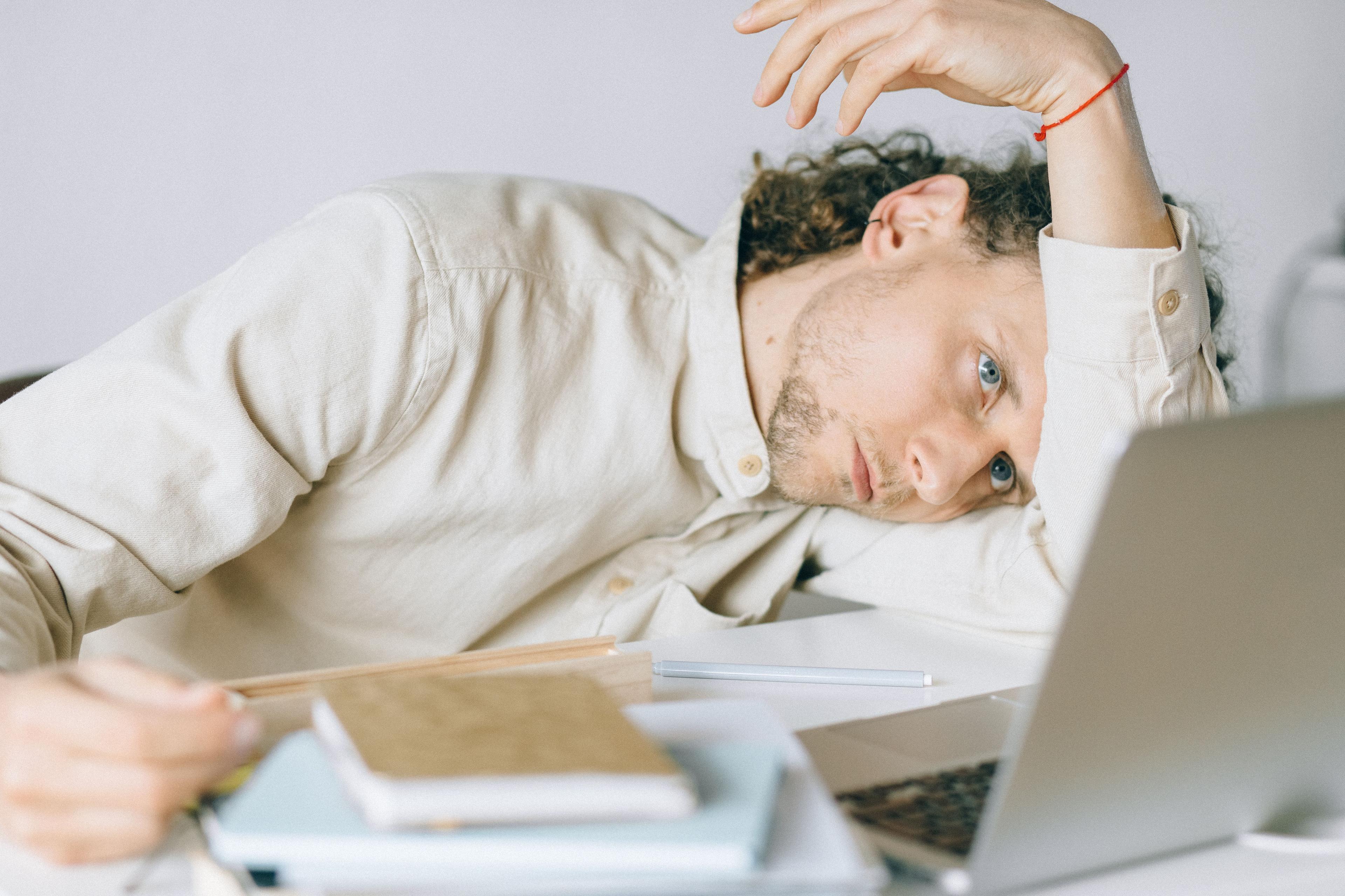 Entspannter Mitarbeiter bei Pausenübung als Teil der Burnout-Prävention im Unternehmen Entspannter Mitarbeiter bei Pausenübung als Teil der Burnout-Prävention im Unternehmen