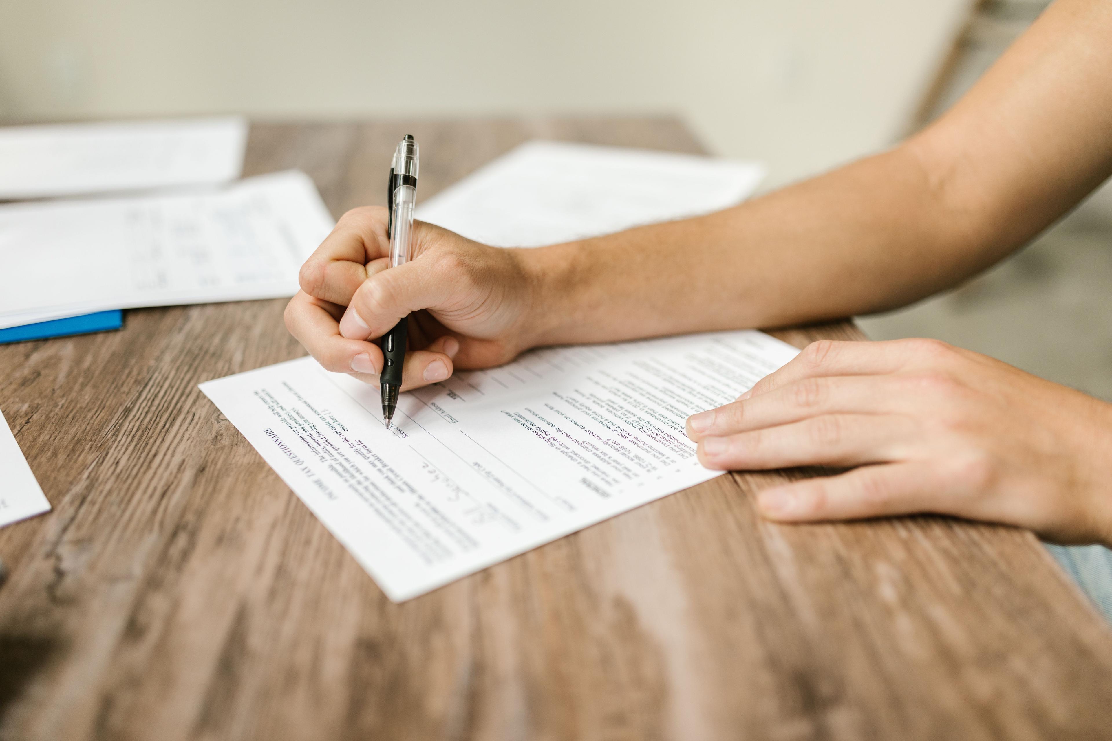 Antragsteller füllt Arbeitslosengeld-Formulare bei der Agentur für Arbeit aus Antragsteller füllt Arbeitslosengeld-Formulare bei der Agentur für Arbeit aus