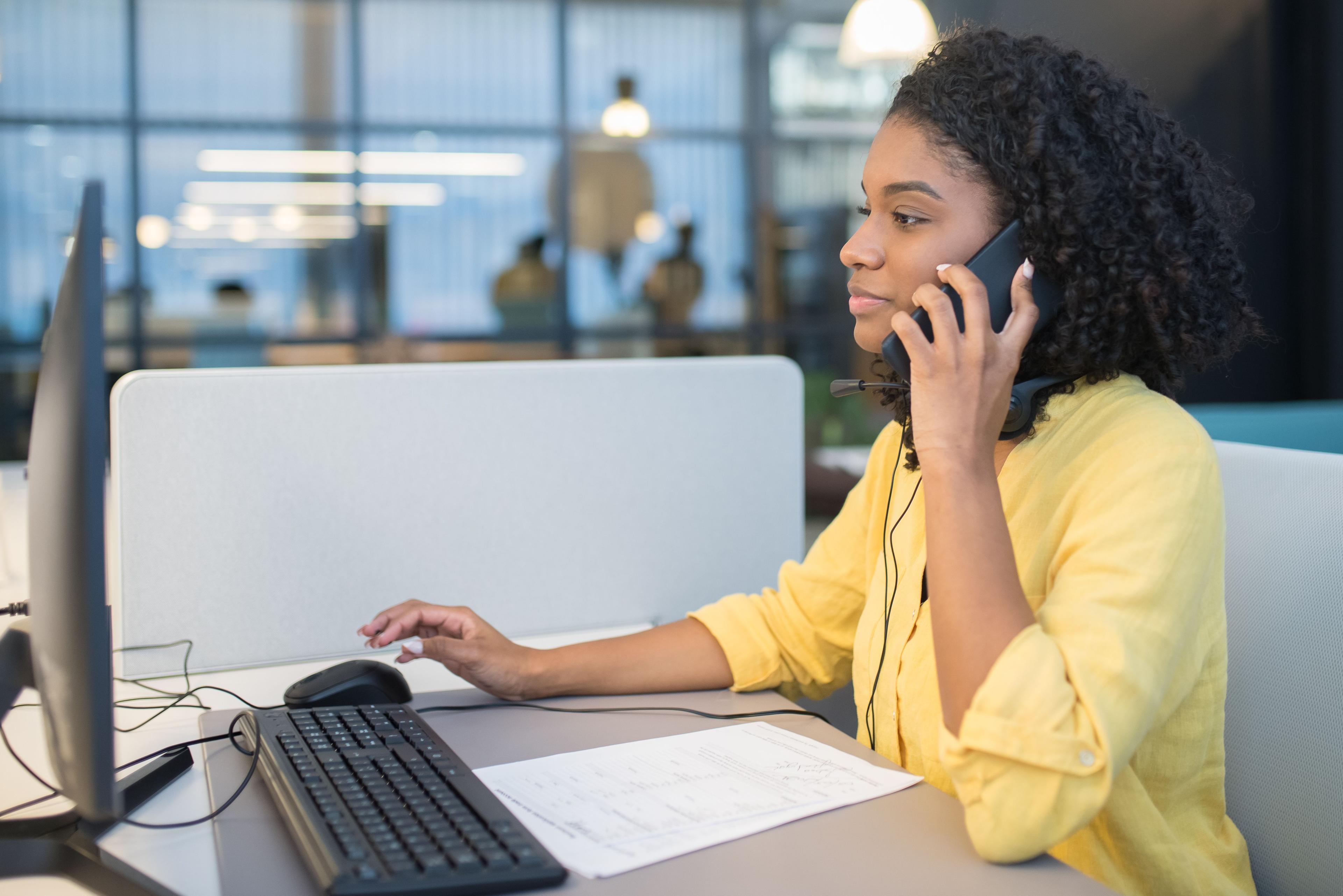Geschäftsfrau nutzt Firmenhandy für berufliche Telefonate im Büro Geschäftsfrau nutzt Firmenhandy für berufliche Telefonate im Büro