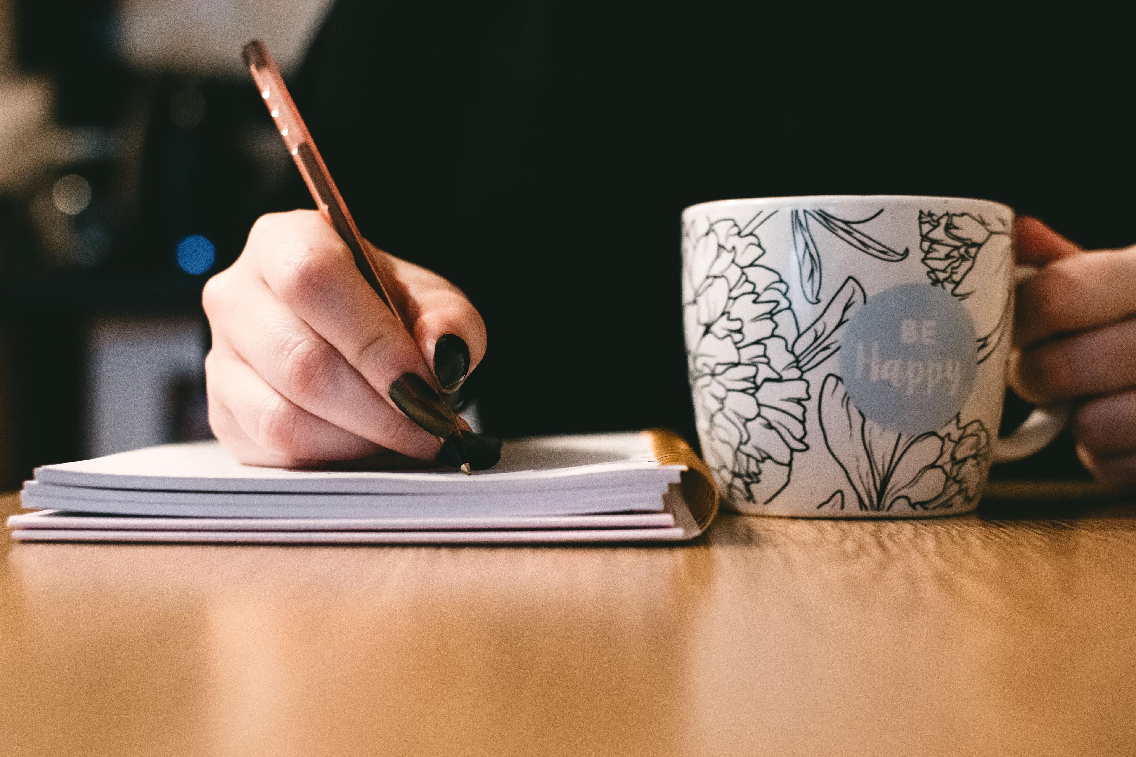 Hand hält Stift beim Verfassen eines Arbeitszeugnisses Hand hält Stift beim Verfassen eines Arbeitszeugnisses